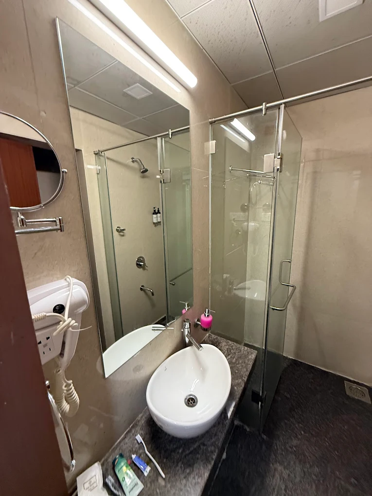 A luxurious bathroom with a soaking tub, a separate shower, and premium toiletries, highlighting the upscale amenities available at Hotel Swamiraj.